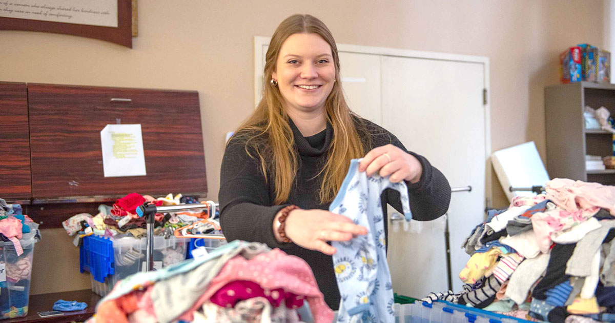 Woman sorts baby clothes